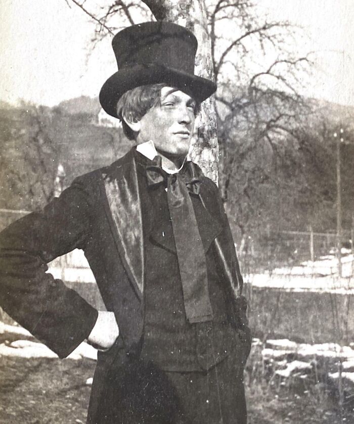 Man in formal attire with top hat, posing outdoors, exemplifying how the world has changed over decades.