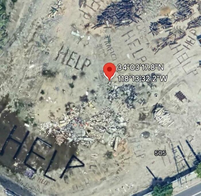 Strange Google Earth image showing "HELP" written on the ground with a location pin.