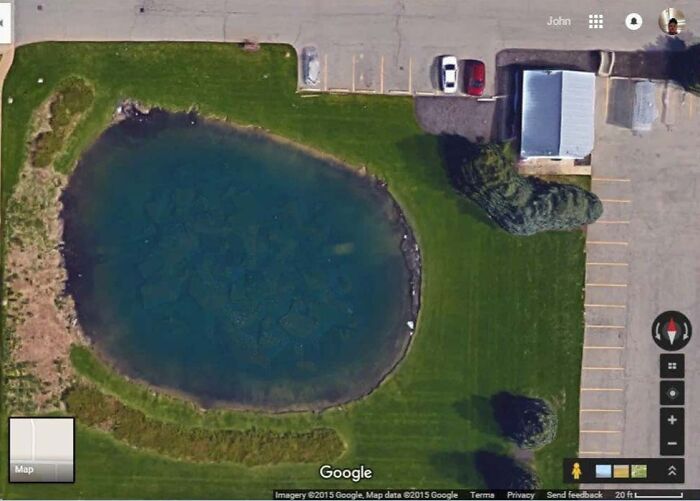 Aerial view of a small pond beside a parking lot, found on Google Earth.