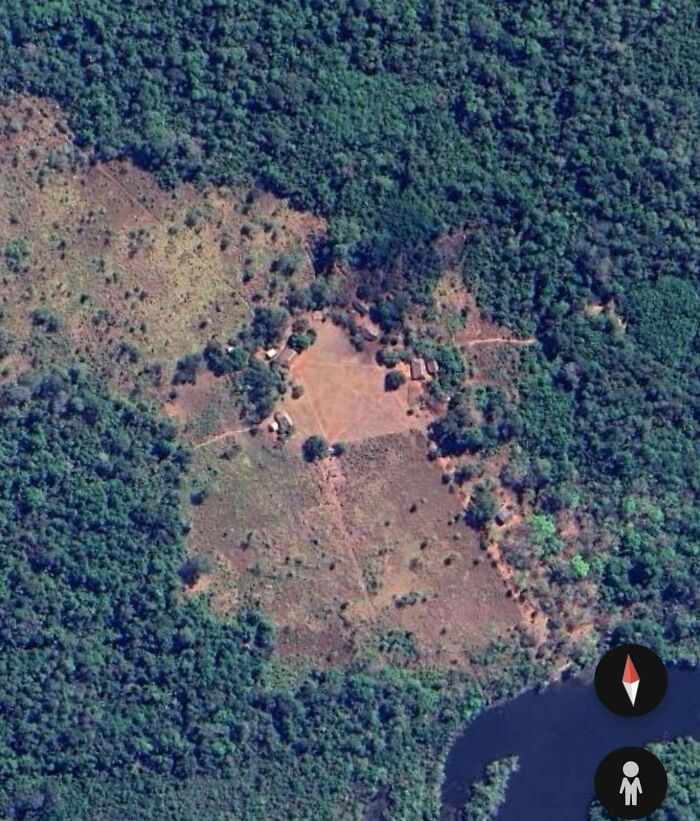 Aerial view of a clearing with structures in the forest, found on Google Earth.