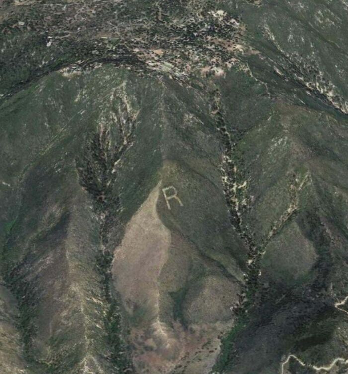 Letter "R" on a hillside discovered using Google Earth, showcasing strange findings from satellite imagery.