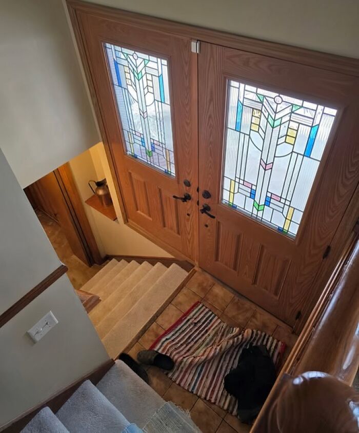 Puerta con vitrales de colores al pie de una escalera. Ejemplo de arquitectos que fracasaron.