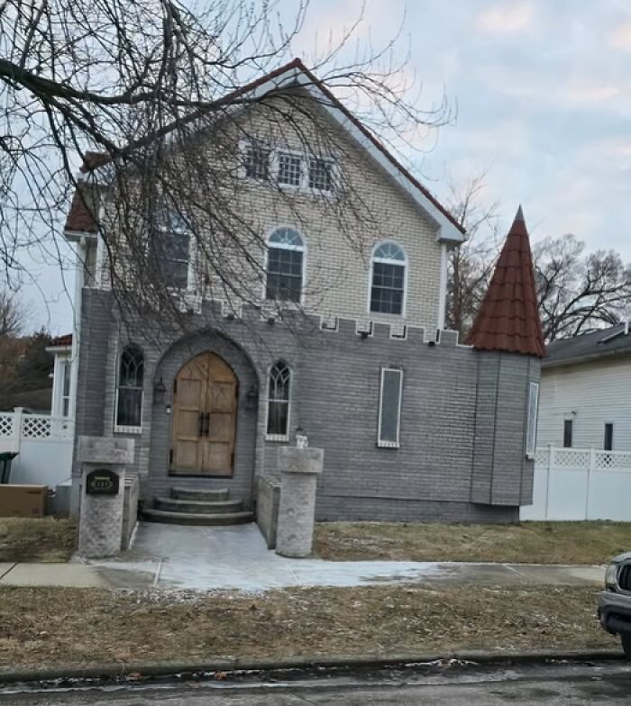 Casa de diseño arquitectónico inusual, similar a un castillo, en un vecindario residencial.