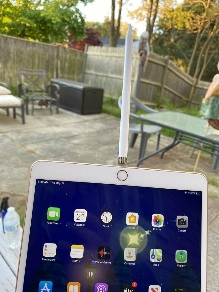 Tablet with a pencil inserted into the charging port, illustrating a design fail outdoors on a patio.