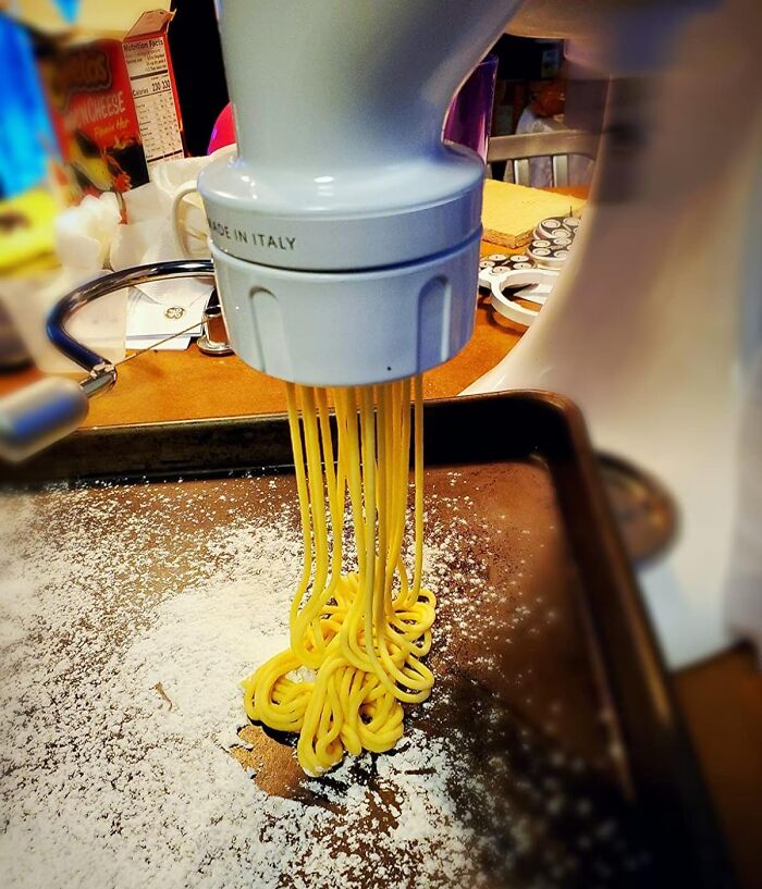 Pasta maker extruding fresh noodles onto a floured tray, showcasing Amazon spring deals.