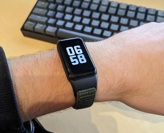 Smartwatch displaying 06:58 on wrist, next to a keyboard, highlighting Amazon spring deals.