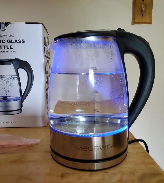 Glass electric kettle with blue LED lighting on a wooden surface, featuring Amazon spring deal.