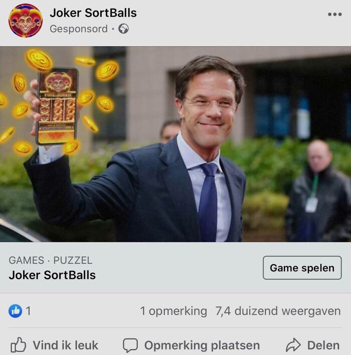 Man in a suit smiling, holding a phone showing a shameless scam game with coins floating around.