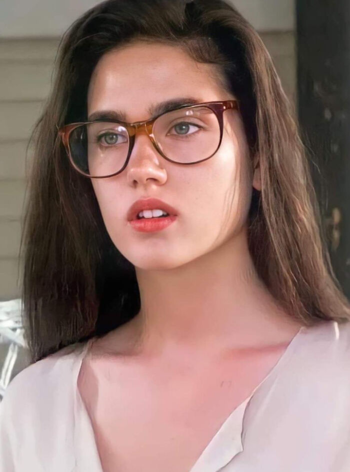 Young woman with glasses and long hair, evoking nostalgic 90s style and simpler, stranger days of the decade.
