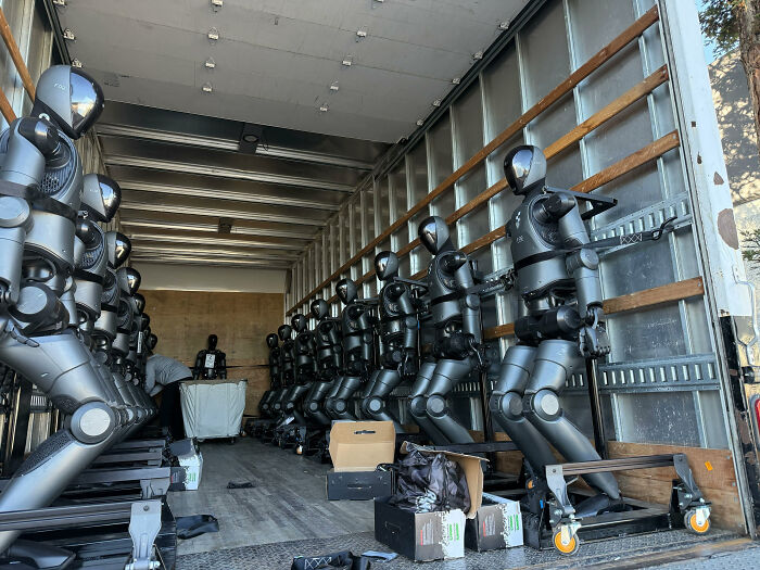 Robotic humanoid figures lined up inside a truck for transport