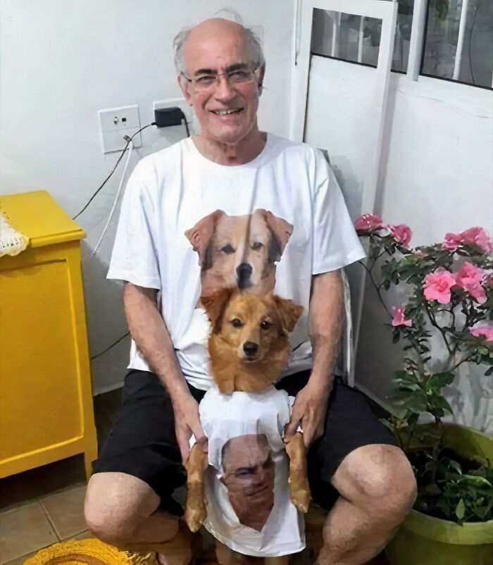 Man and dog wearing chaotic T-shirts featuring each other's faces, sitting in a bright room.