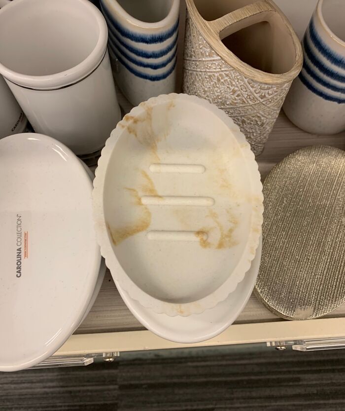 Design fail with stained soap dish among clean bathroom accessories.