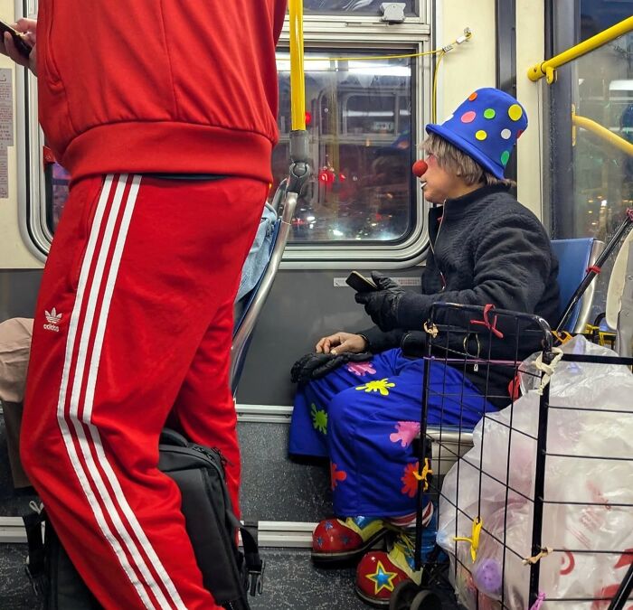 A person in playful clown attire sits on a San Francisco bus, captured vividly by a photographer’s lens.