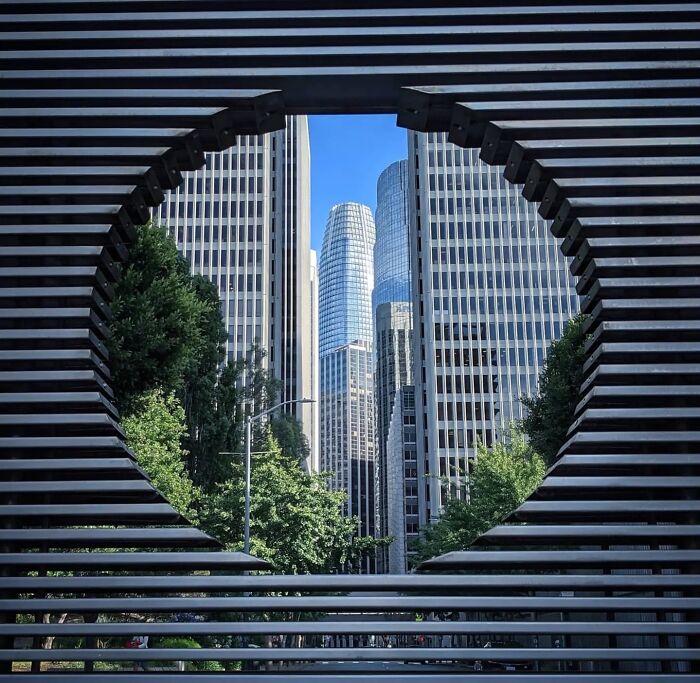 San Francisco skyline framed by a modern circular structure, showcasing urban architecture.