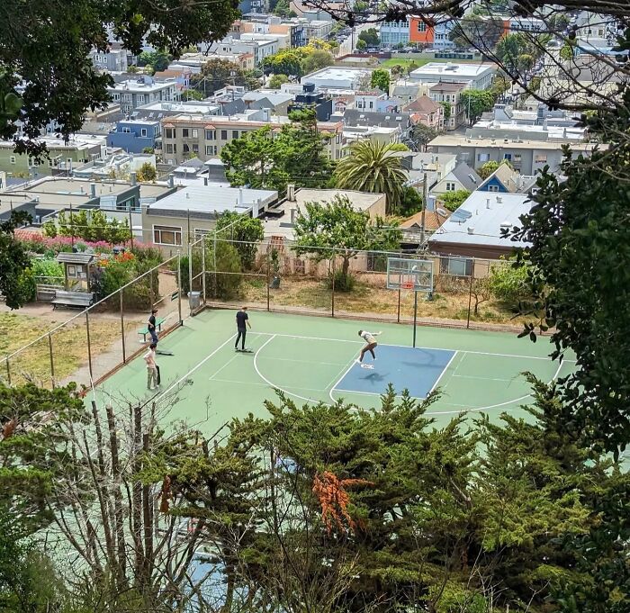 San Francisco cityscape with people playing basketball on an outdoor court, captured through Sage Akaboshi's lens.