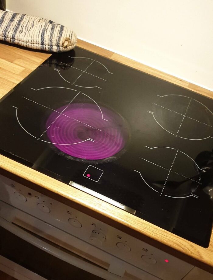 Stovetop design fail showing misaligned burners with one burner improperly lit in purple.