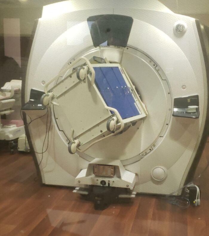 Expensive accident with large medical equipment fallen on its side in a hospital room, causing noticeable disruption.