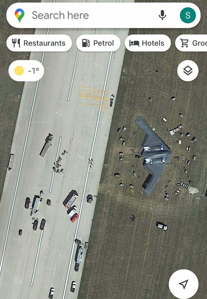 Aerial view of a runway with vehicles and personnel around a damaged aircraft, depicting an expensive accident.