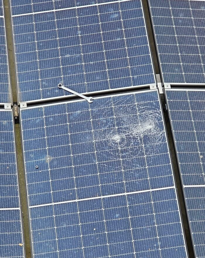 C*****d solar panel with a wrench left on the surface, illustrating a costly accident.