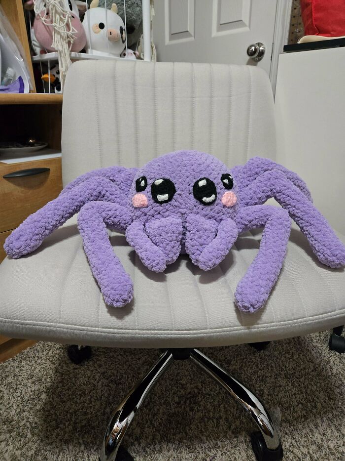 Crochet enthusiasts crafted an adorable large purple spider plush with big eyes and blush made from soft yarn.