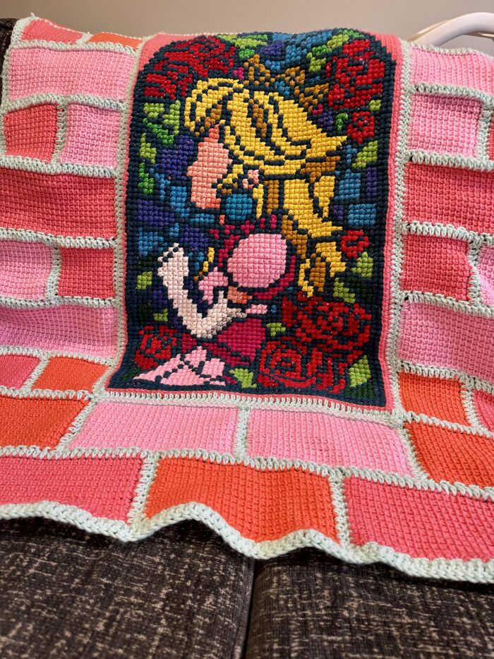Colorful crochet blanket featuring a detailed portrait of a blonde girl surrounded by roses and geometric patterns.