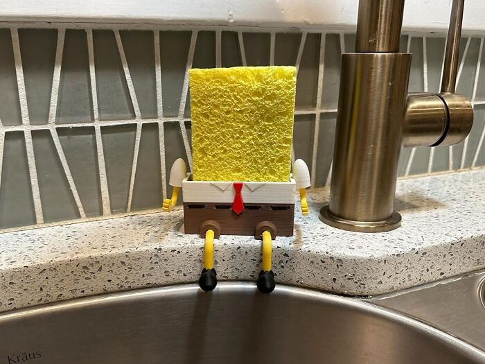 Sponge holder shaped like a cartoon character, a kitchen game-changer, on a countertop by the sink.