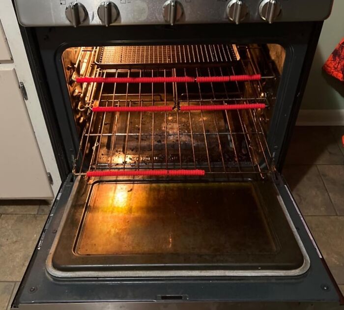Open oven with protective red covers on racks; a kitchen game-changer.
