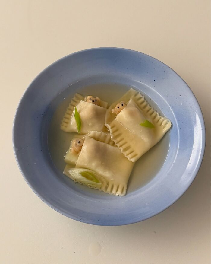Adorable food art by Korean artist features dumplings with cute bear designs in blue bowl.