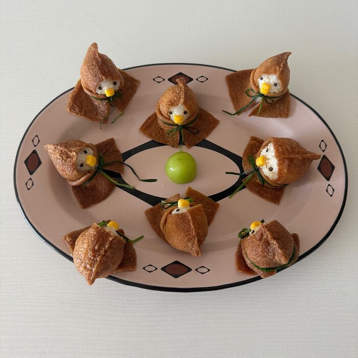 Adorable food art of eight bird-shaped snacks on a patterned plate by a Korean artist.