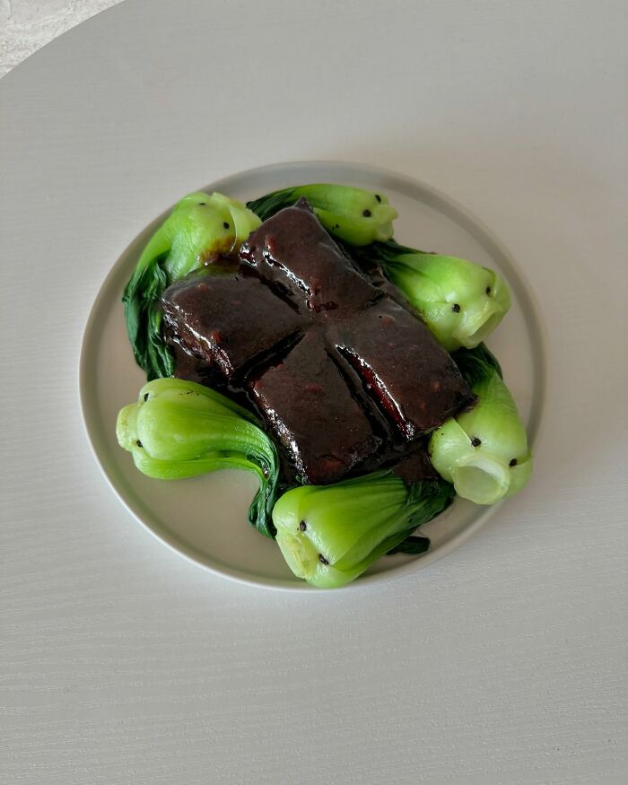 Adorably arranged food art with creatively shaped bok choy on a white plate.