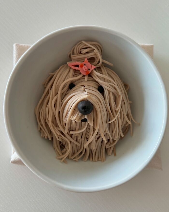 Adorable food arrangement of a noodle dog in a bowl by a Korean artist.