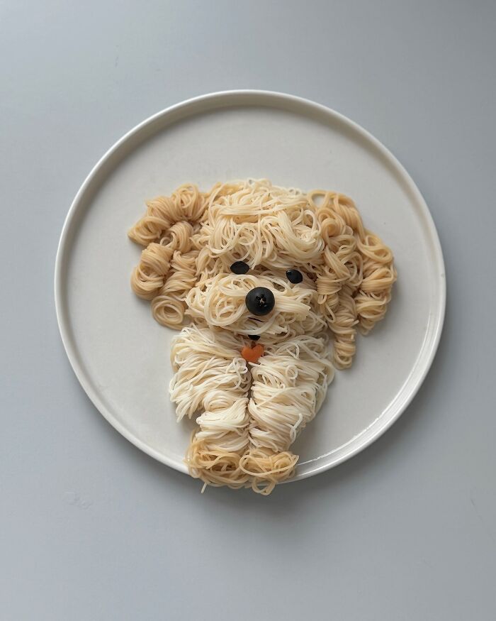 Adorable food art of a cute puppy made from noodles on a white plate by a Korean artist.
