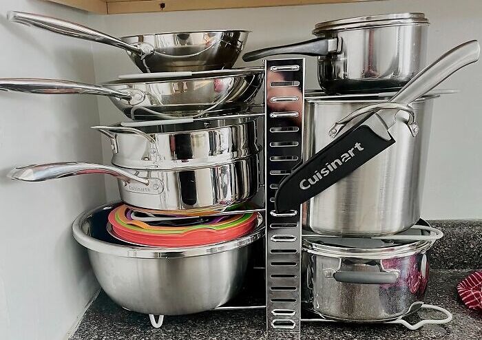 Stacked kitchen game-changers with pots, pans, and a colorful cutting board on a countertop.