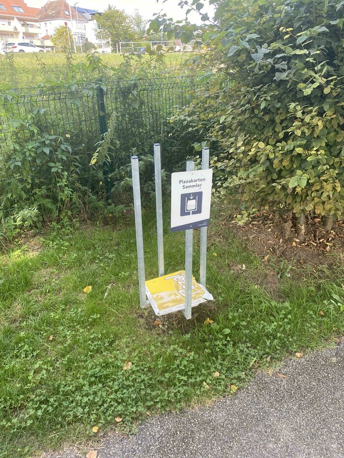 Pizza box recycling stand in a park, showcasing a unique way countries care for their citizens.