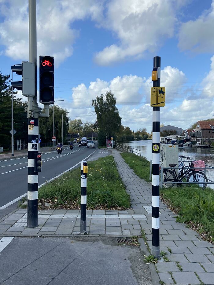 Bicycle-friendly traffic light and signs in a peaceful street, highlighting ways countries care for citizens.