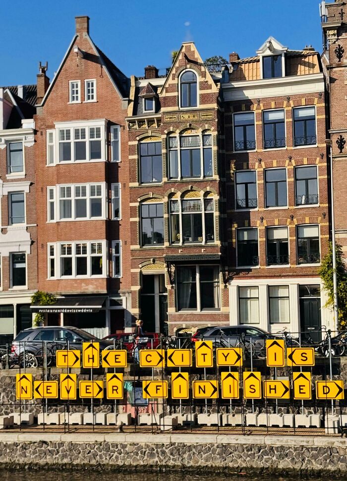 Historic buildings with a sign reading "The City Is Never Finished" highlight ways countries care for citizens.