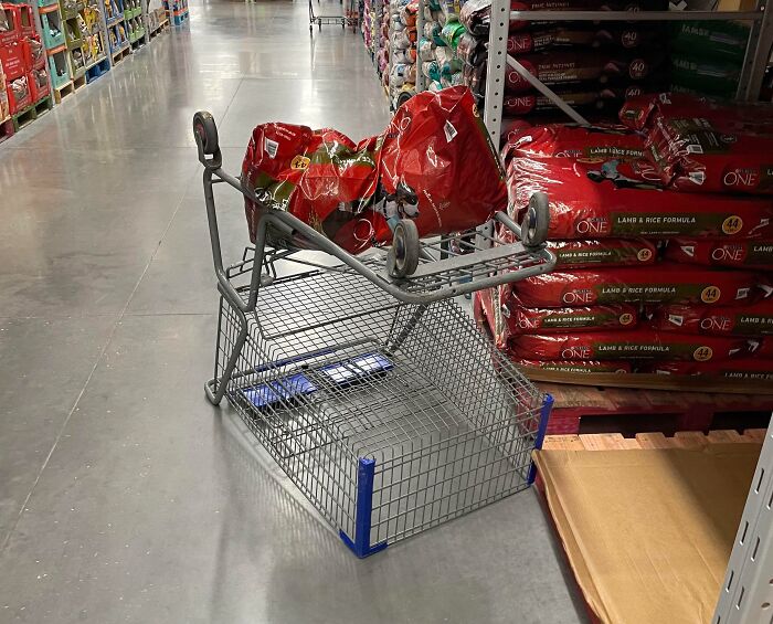 Shopping cart flipped upside down in an aisle, showcasing customer cluelessness.