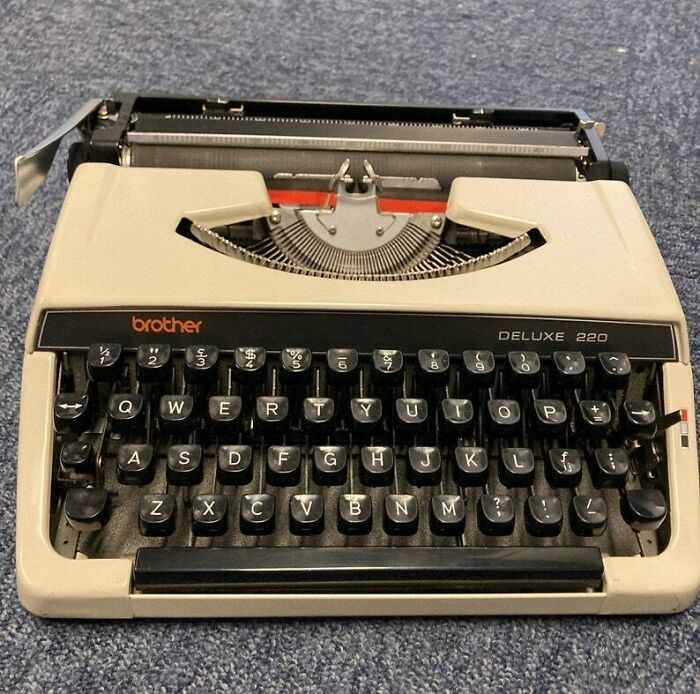 Vintage 1980s Brother Deluxe 220 typewriter on a textured surface.