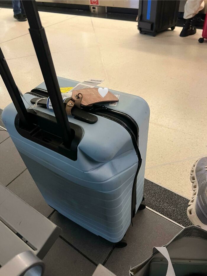 Damaged blue suitcase with dented corner, illustrating airline baggage fail at airport.