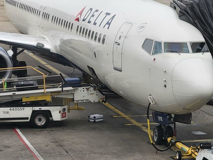 Delta airplane at the gate with baggage loaded, showcasing an example of airline baggage fails.