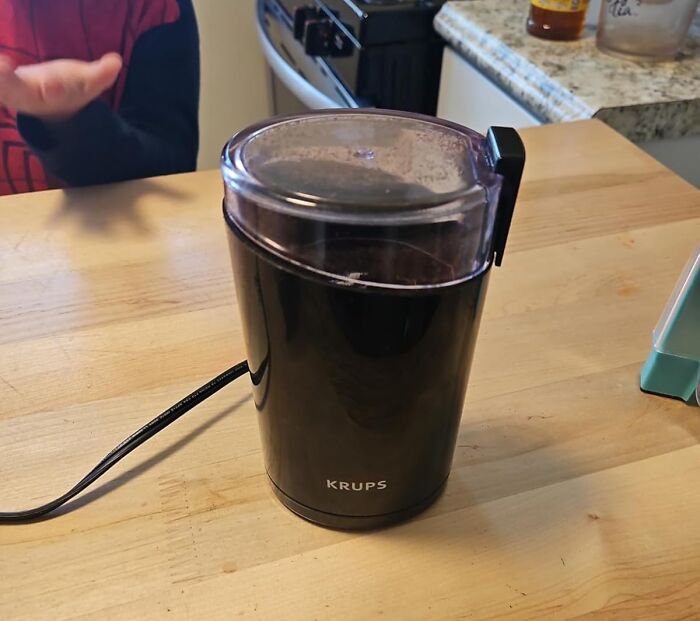 Krups coffee grinder on a kitchen table, enhancing quality of life with convenient coffee preparation.