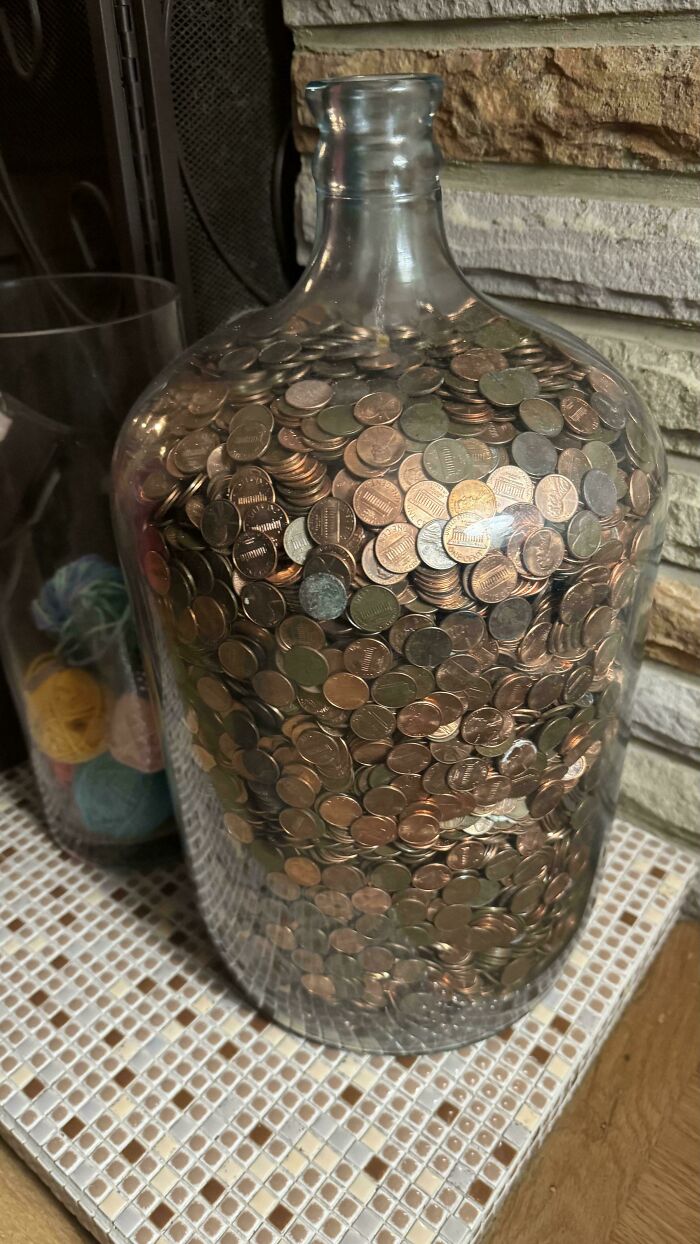 Large glass jar filled with coins, representing interesting artifacts found in old houses.