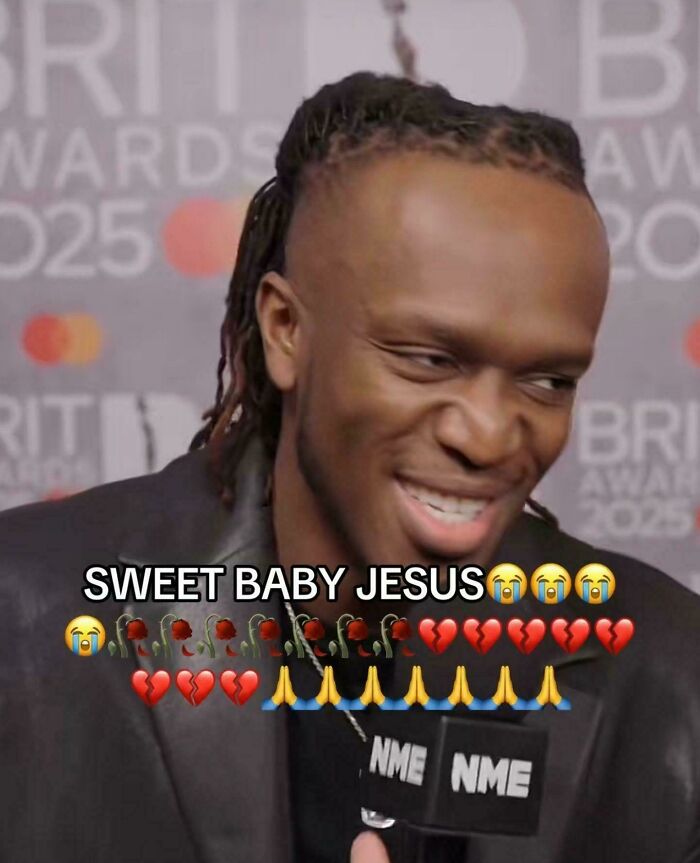 Man smiling with an unfortunate haircut, shaved sides and dreadlocks on top, at an awards event.