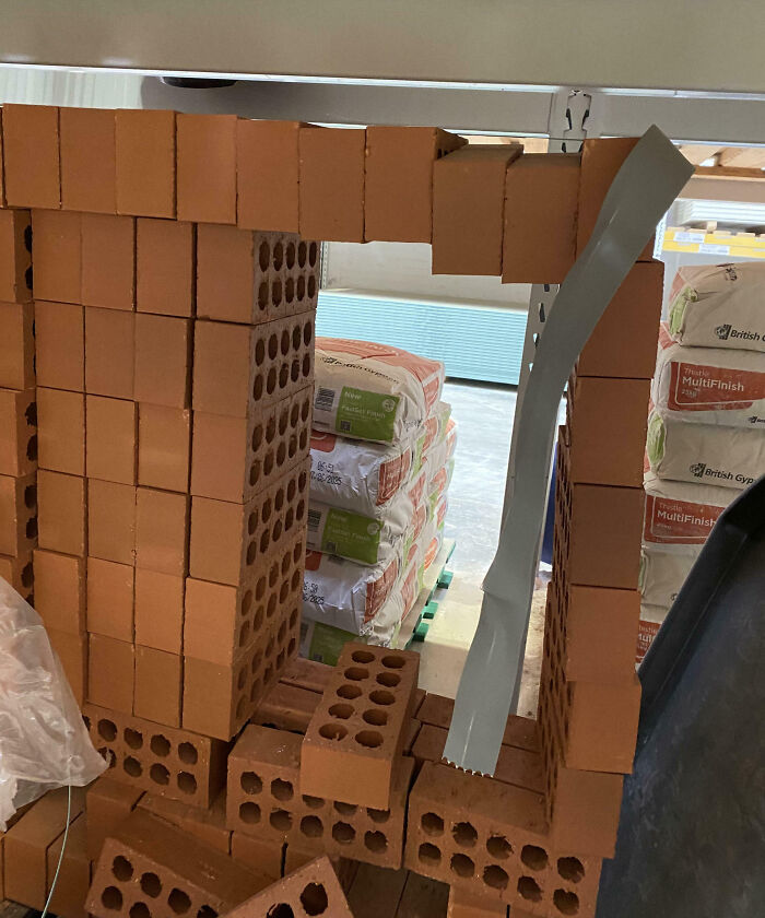 Bricks stacked awkwardly, creating a makeshift archway, illustrating customer cluelessness.