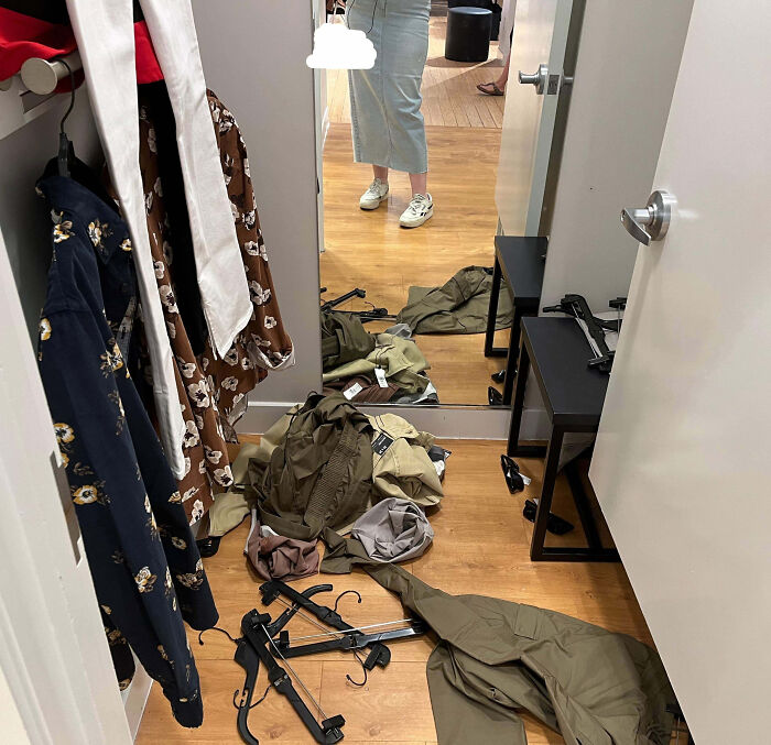 Messy fitting room with clothes and hangers scattered on the floor, showcasing customer cluelessness.