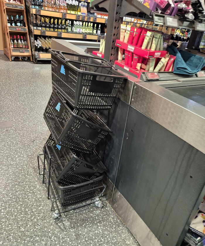 Grocery store checkout area with misplaced shopping baskets stacked unusually beside the counter.