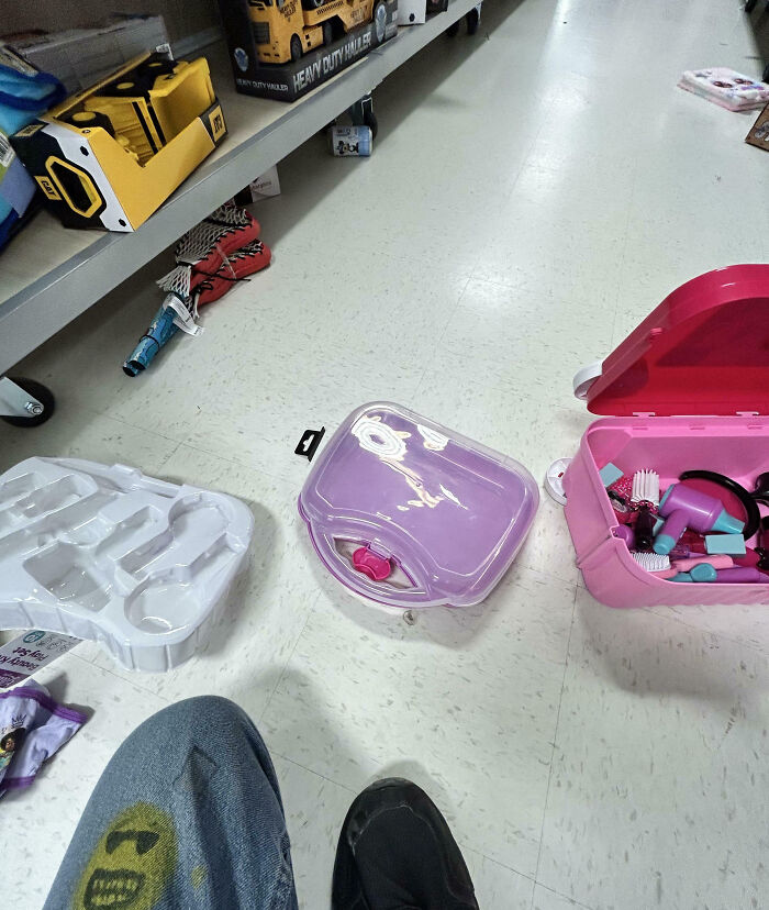 Scattered toy parts and packaging on store floor, illustrating customer cluelessness.