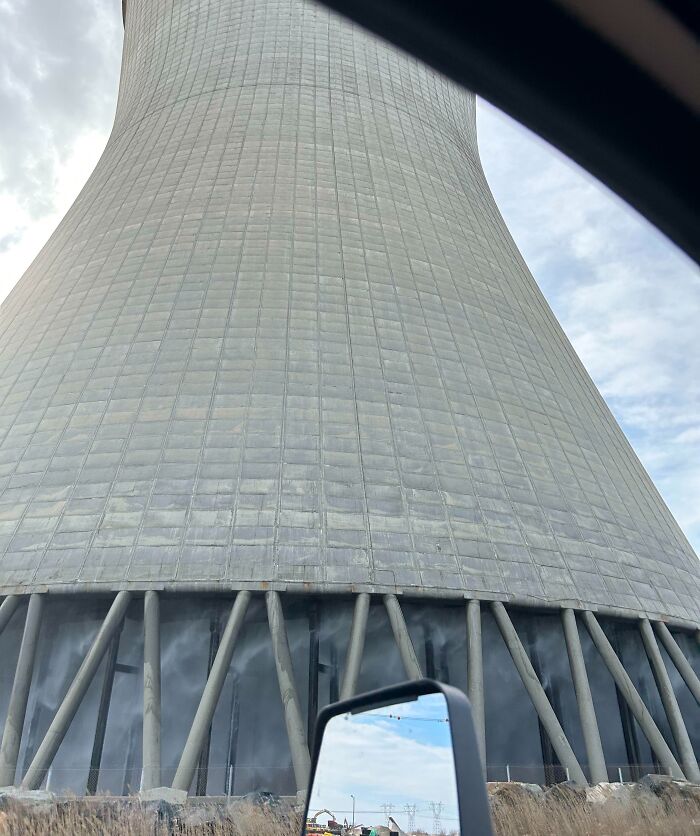 Cooling tower of an iconic power plant viewed from inside a car.