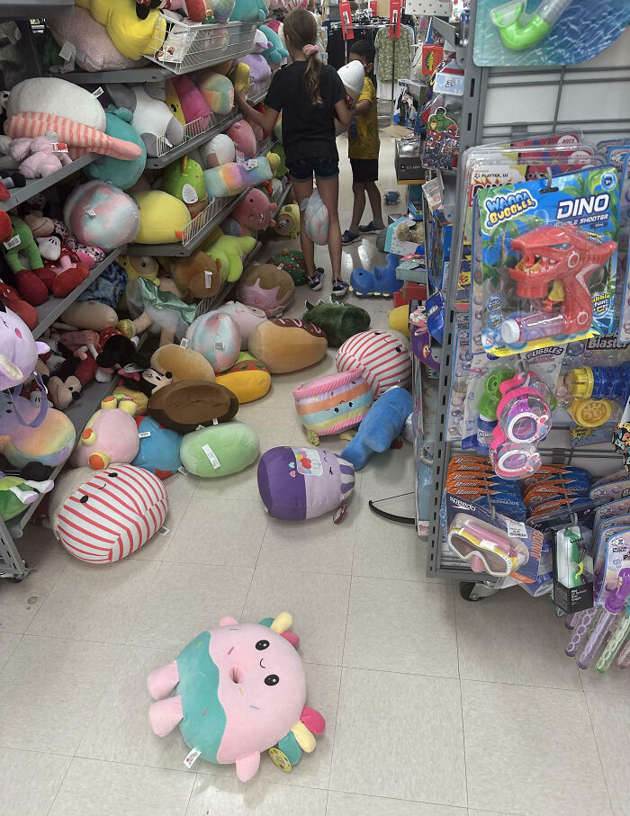 Customers create plush chaos in toy aisle, with stuffed animals scattered everywhere.