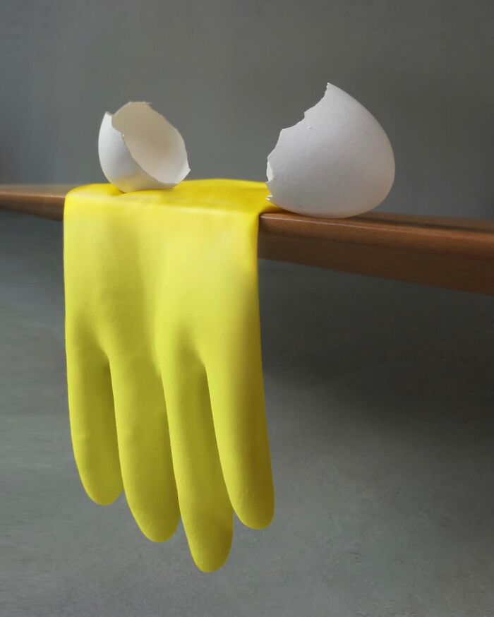 Yellow glove illusion blends with an eggshell, showcasing Dudi Ben Simon's artistic fusion.